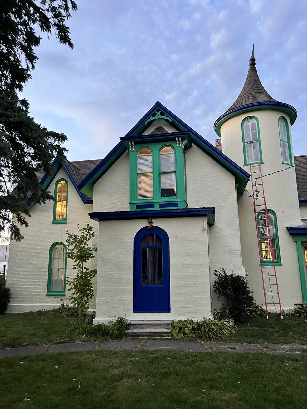 Cream house with a turret and green and blue painted trim